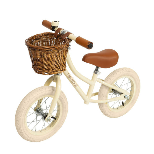 Draisienne 12 pouces, avec panier en osier à l'avant et sonnette. Style vintage, couleur beige crème. Selle et poignée en cuir vegan durable.