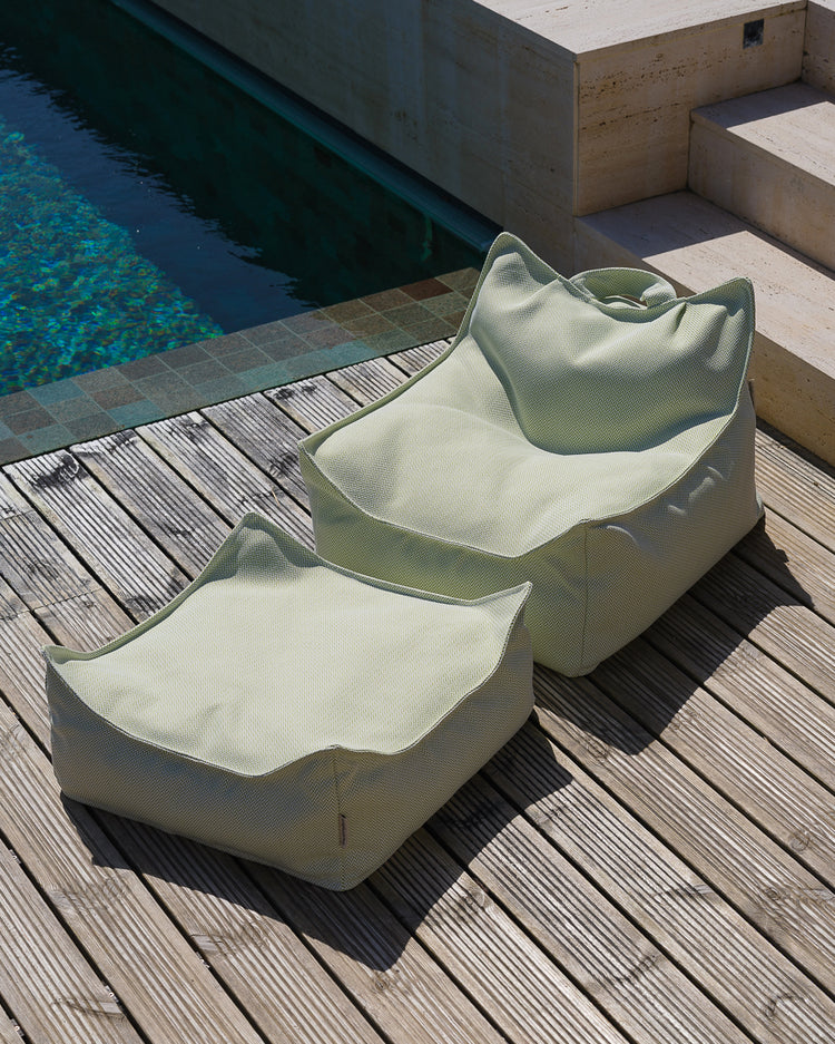 Fauteuil enfant vert Wigiwama posé sur une terrasse extérieure