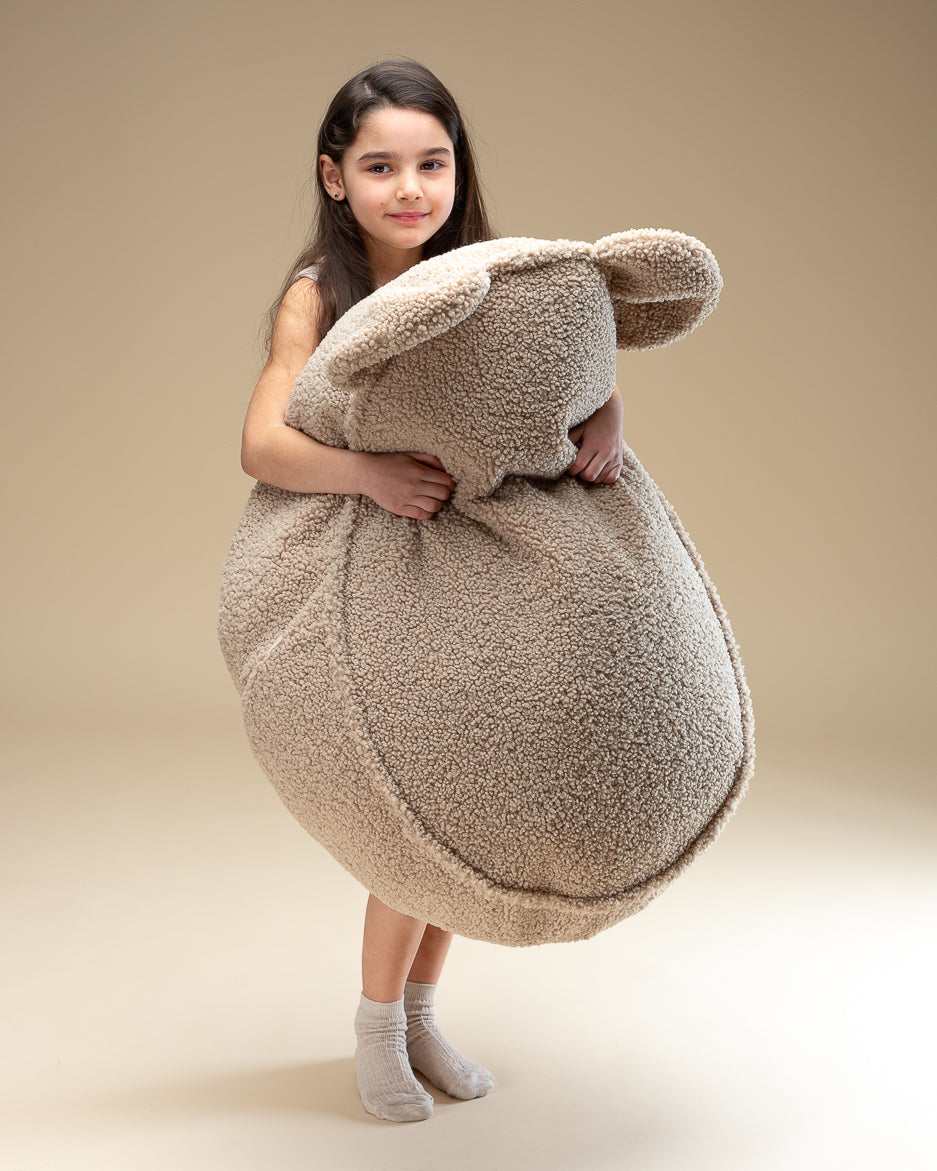 Fauteuil peluche beige pour enfant, apportant une touche de douceur à la chambre