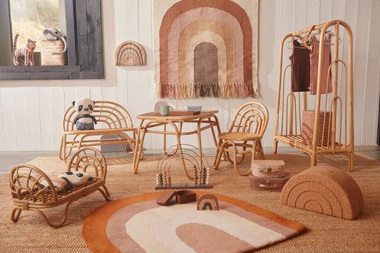 Inspiration décoration chambre bébé avec au centre un tapis en forme d'arc en ciel tons beige et terracotta de la marque OYOY MINI. Tendance vintage, naturel. 