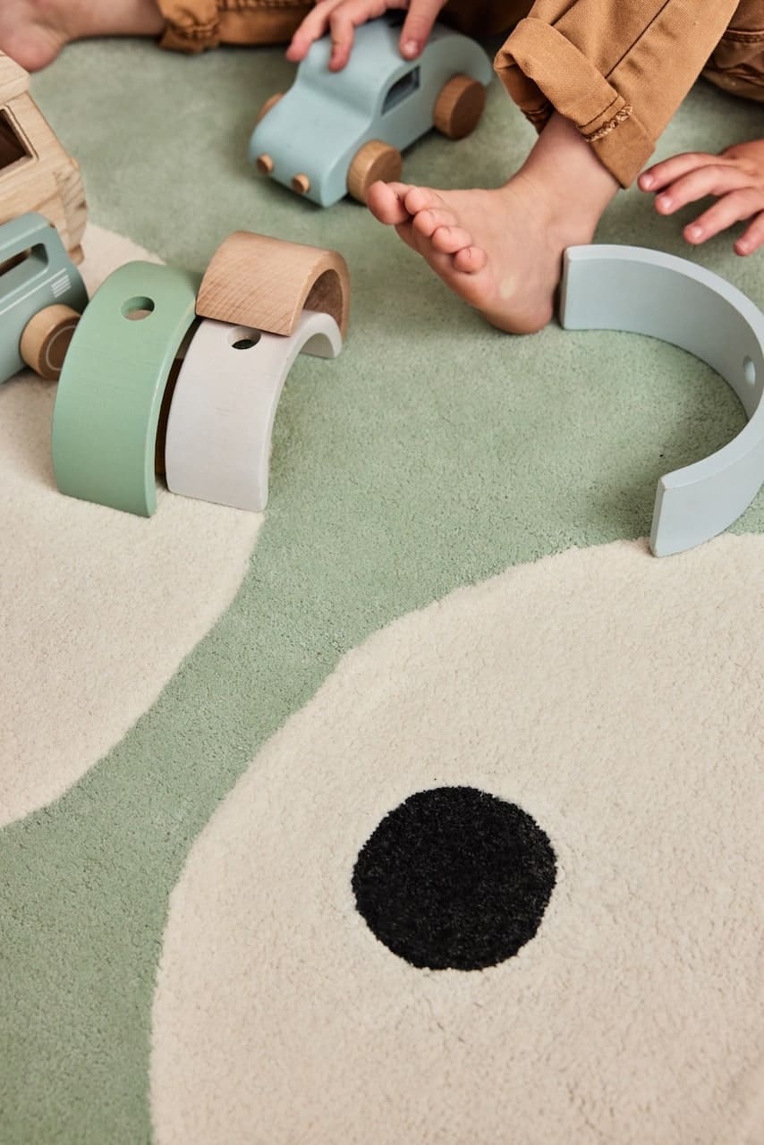 Tapis enfant vert pastel en coton bio certifié GOTS, détail de sa finition artisanale. Parfait pour une décoration éco-responsable.