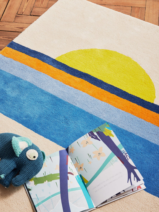 Tapis en coton bio durable, idéal pour décorer un chambre d'enfant ou aménager un coin lecture confortable. Facile à entretenir, motif original. Tapis coloré jaune, bleu et oranger sur fond beige.